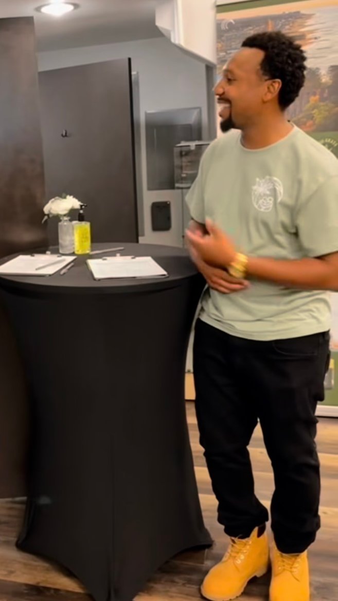 Reel still: a Canopy team member smiling beside the welcome table